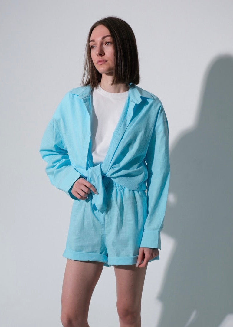 Person wearing a light blue outfit with a white background