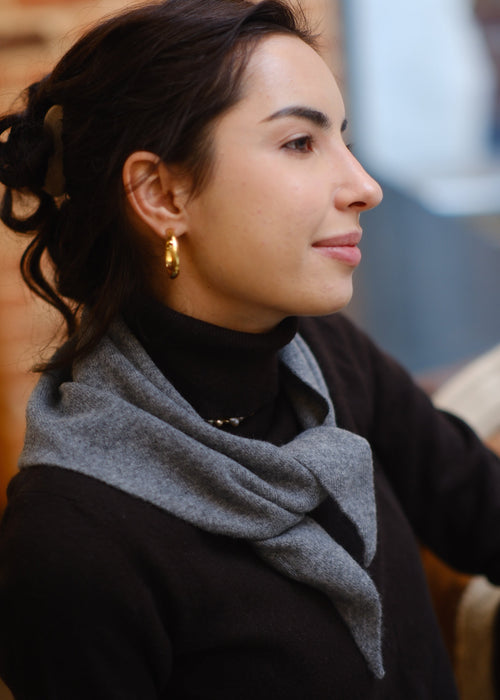 Woman wearing a gold earring looking at something on a surface