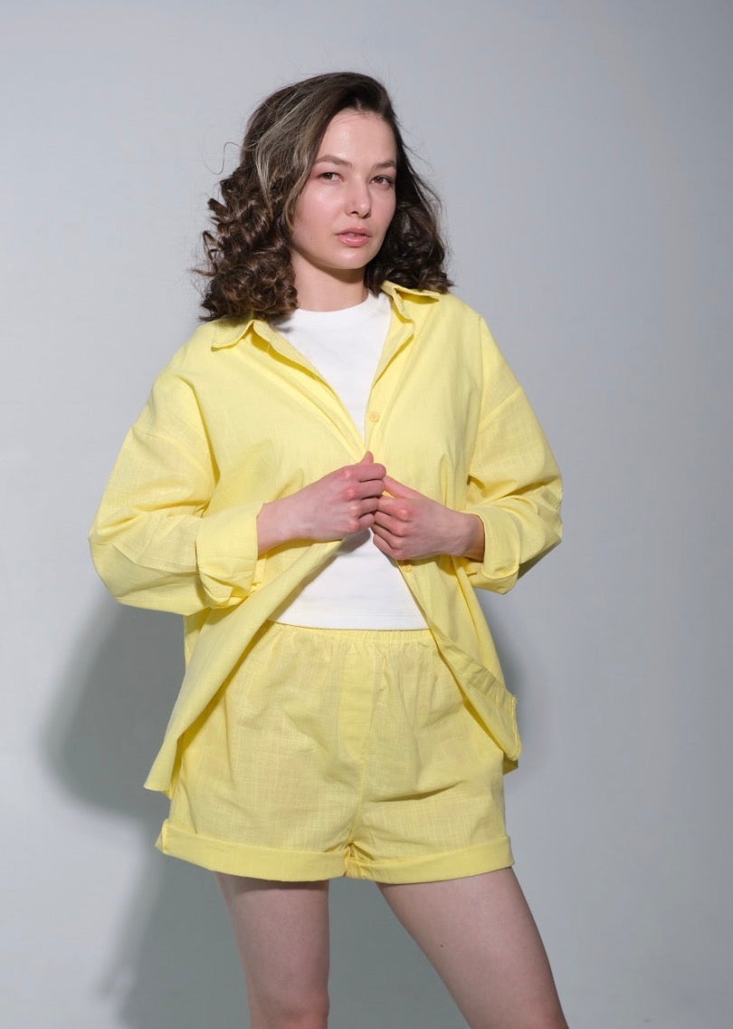 Person wearing a yellow outfit against a plain background