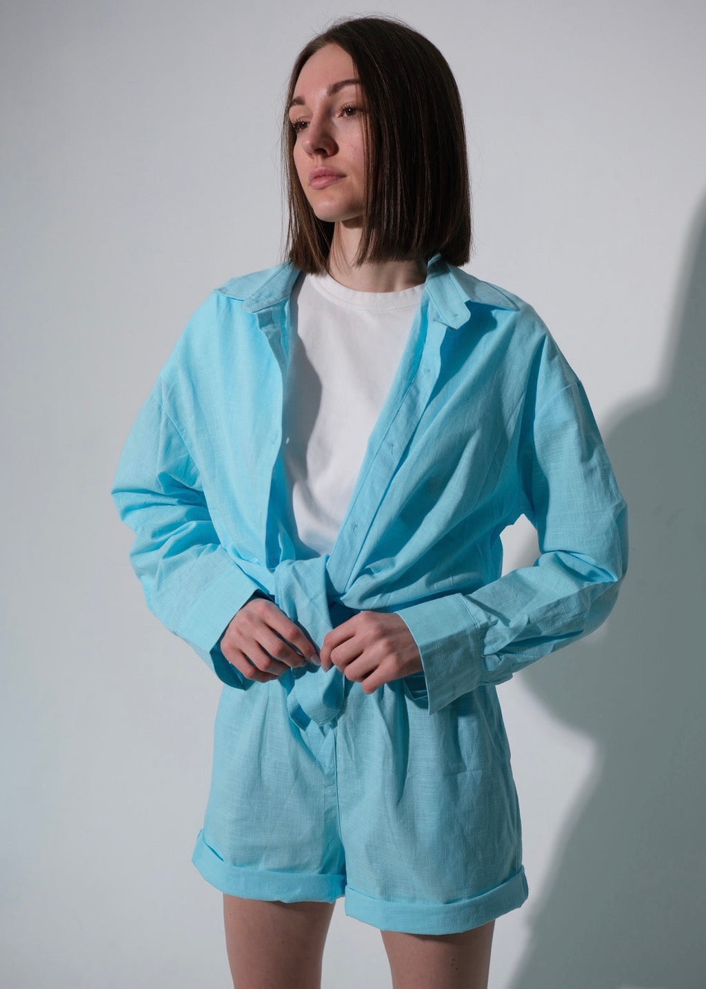Person wearing a light blue tracksuit against a plain background