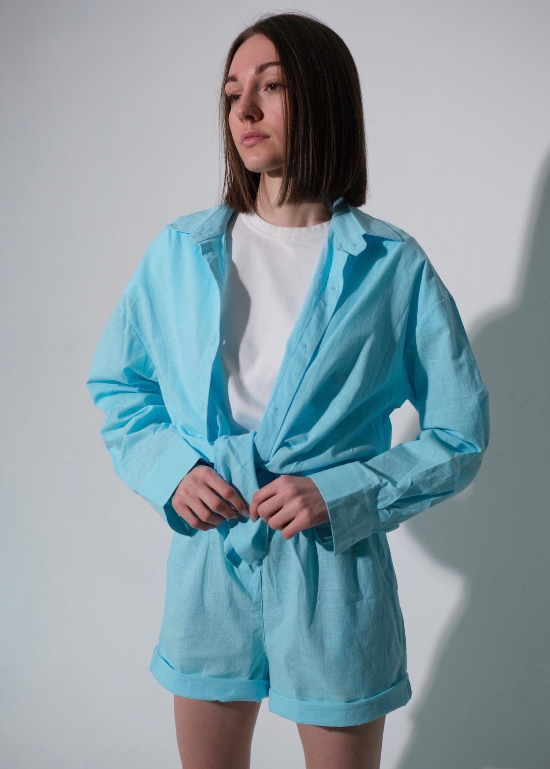 Person wearing a light blue tracksuit against a plain background