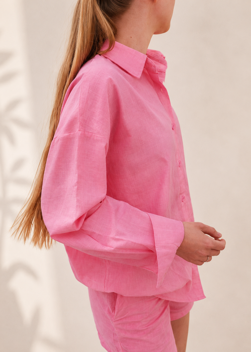 Person wearing a bright pink outfit on a plain background