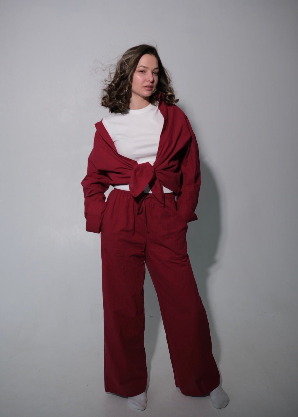 Person wearing a red outfit with a white shirt against a plain background