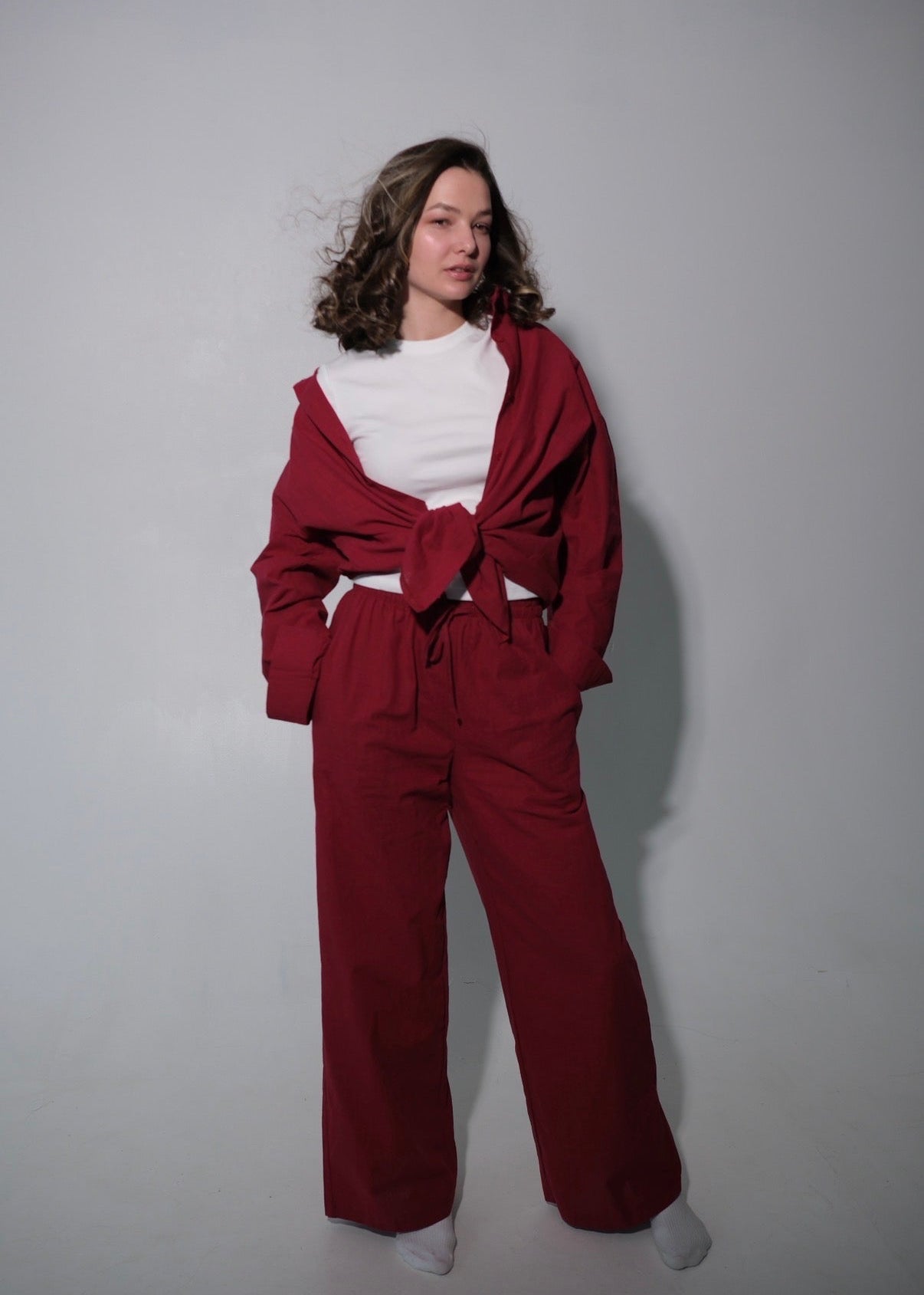Person wearing a red outfit with a white shirt against a plain background