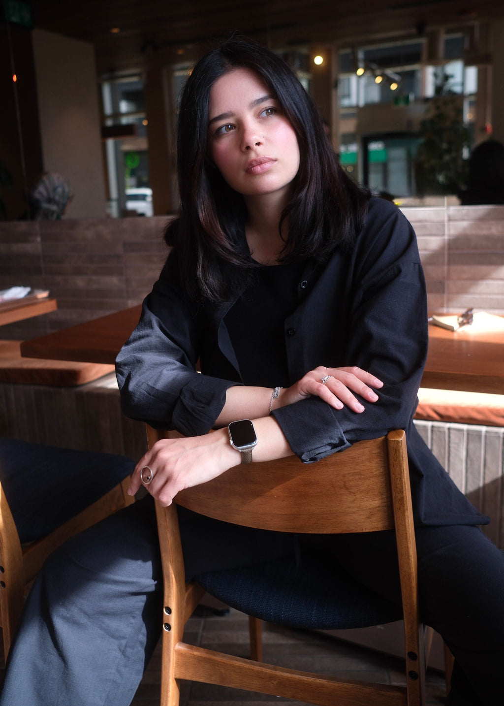 Woman sitting at a wooden table in a restaurant setting