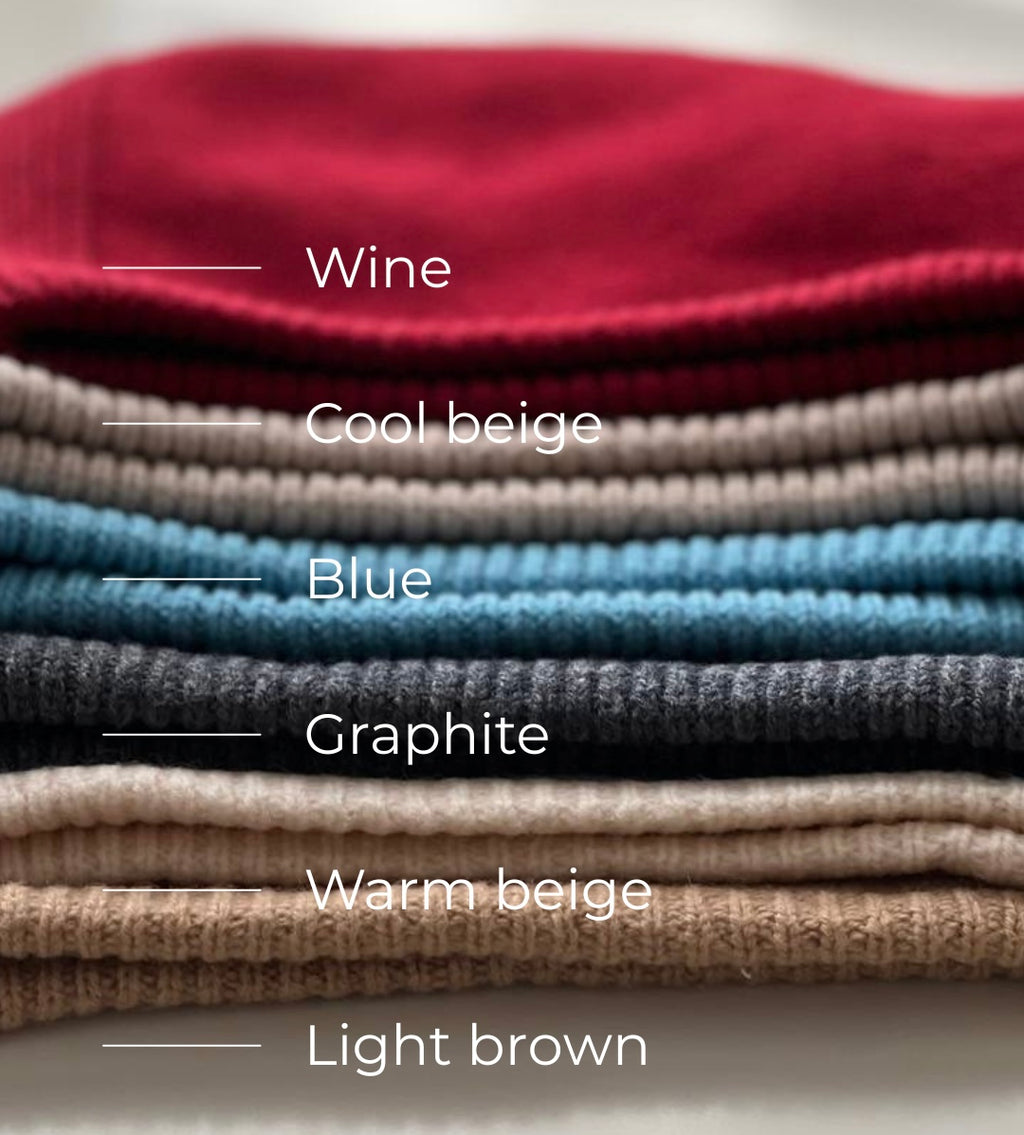 Stack of folded wool hoods in various colors with labels.