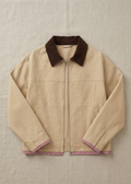 A beige zip-up jacket with a dark brown corduroy collar, laid flat on a textured beige fabric background.