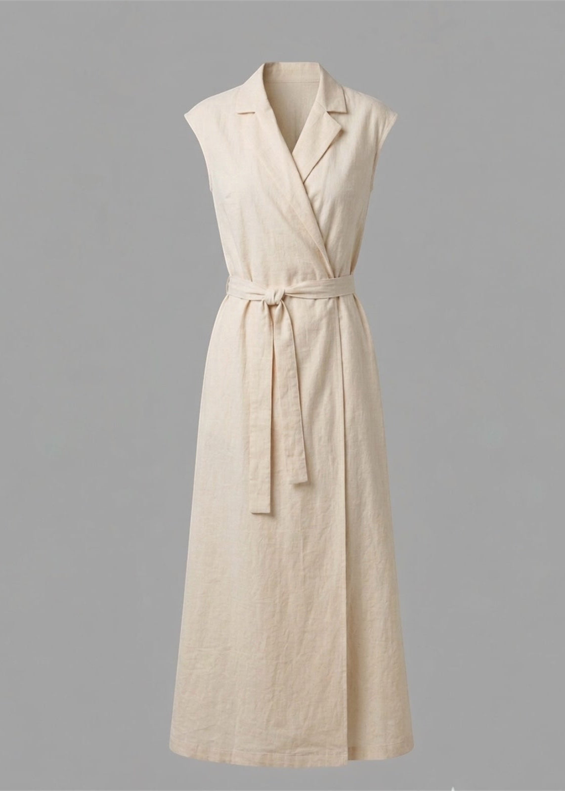 Beige sleeveless dress with a belt on a gray background