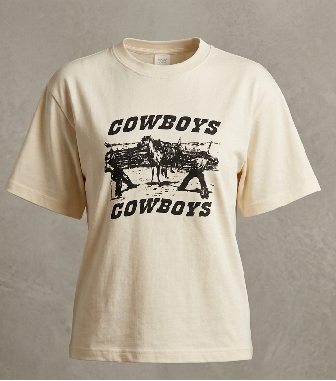 Beige t-shirt with 'Cowboys' graphic on a textured gray background