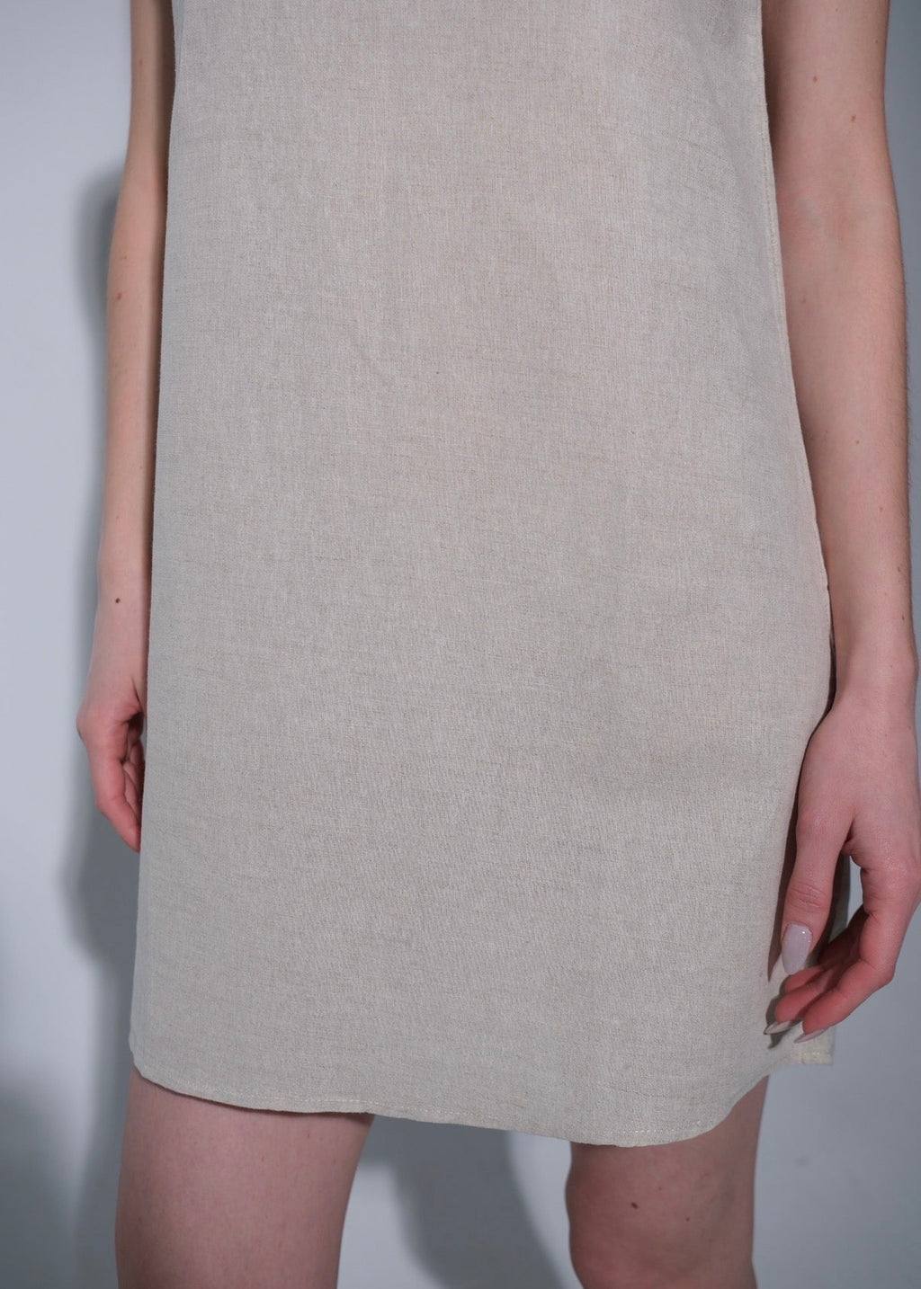 Beige dress worn by a person on a plain background