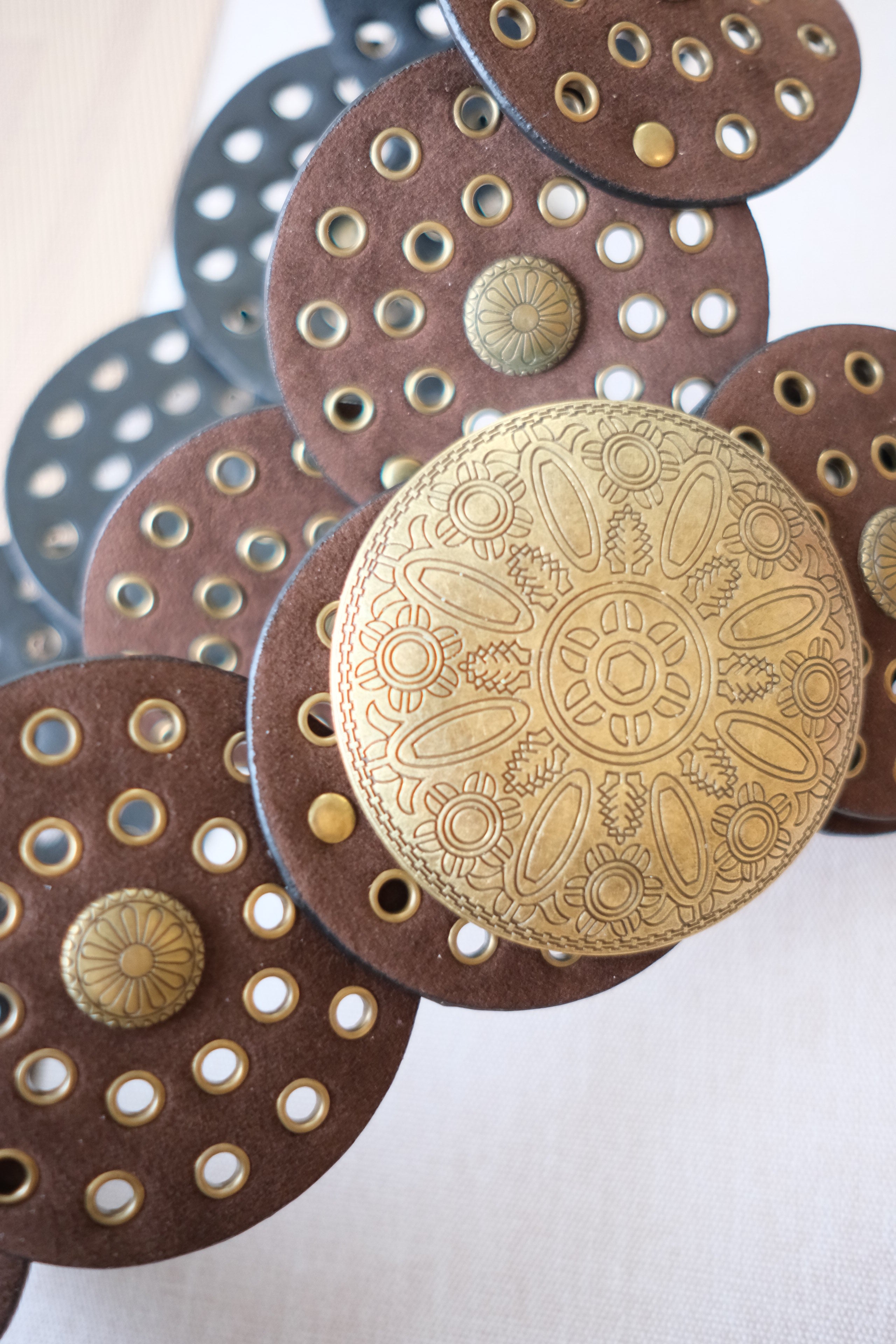 Decorative metal buttons with intricate designs on a white background