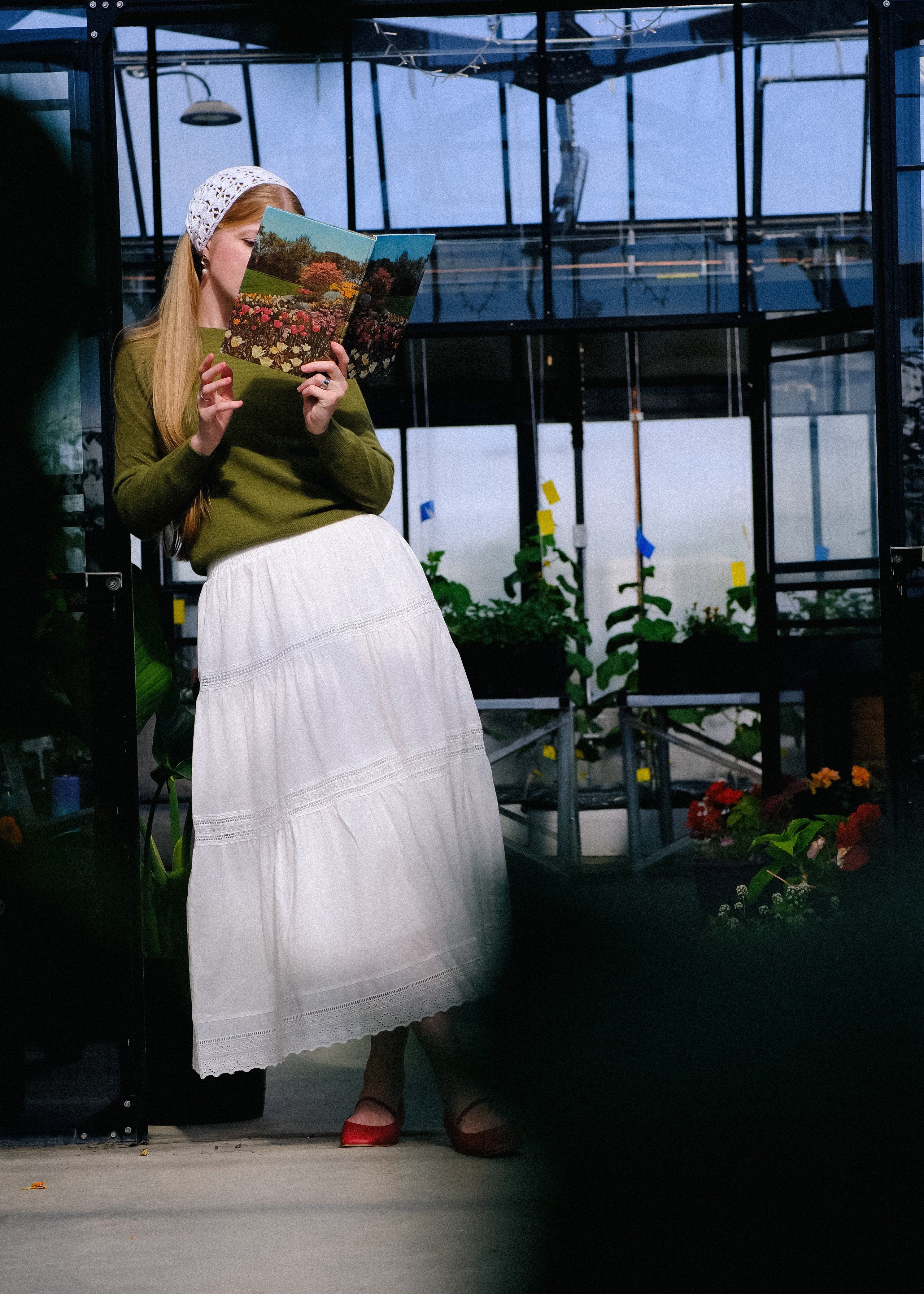 Woman holding a patterned bag in a greenhouse setting