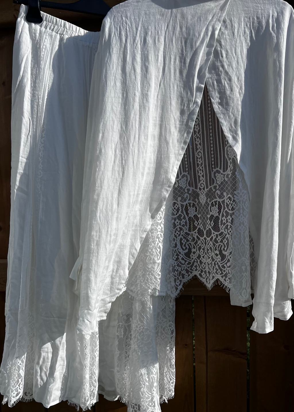 White lace dress hanging on a wooden surface