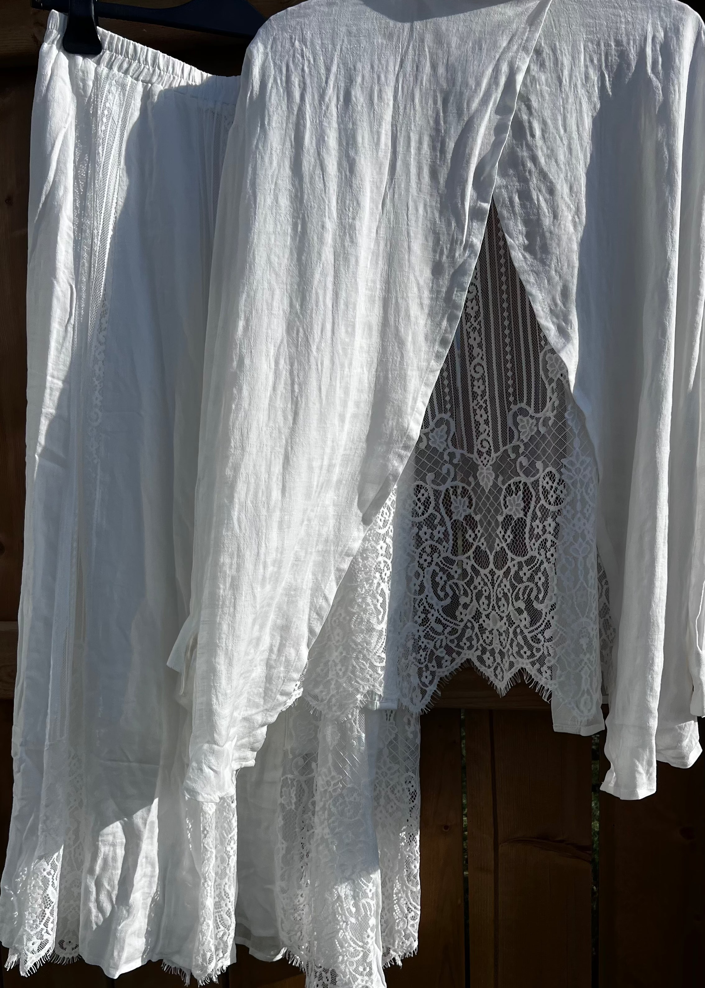 White lace dress hanging on a wooden surface