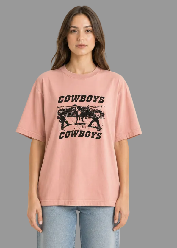 Person wearing a pink t-shirt with 'Cowboys' graphic design on a white background