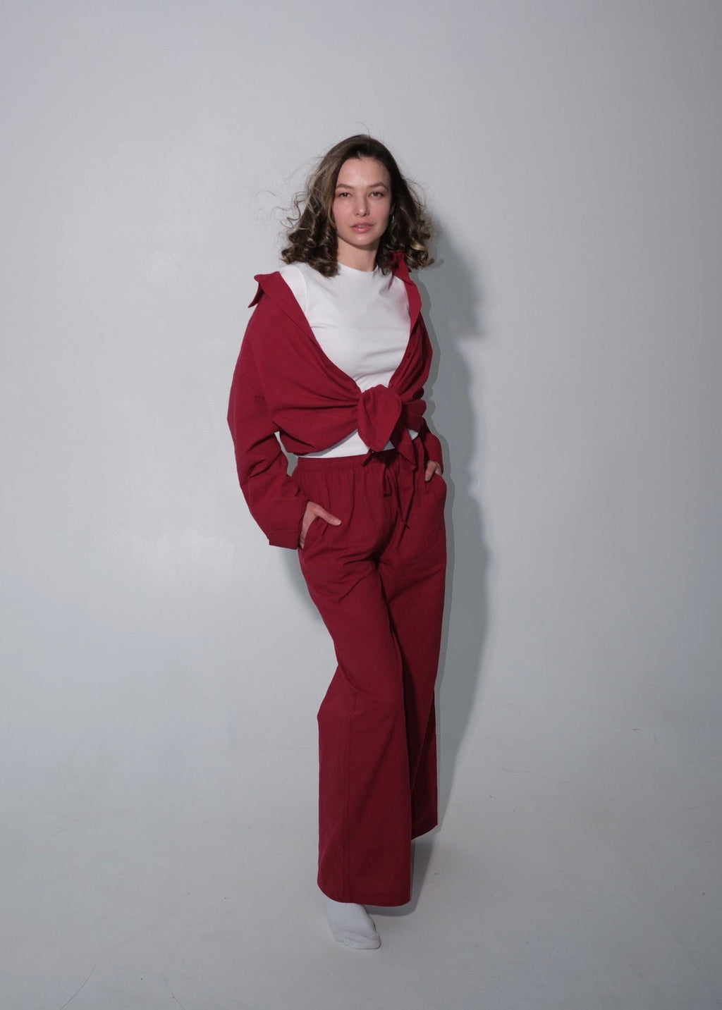 Person wearing a red outfit with a white top against a plain background