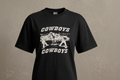 Navy t-shirt with 'Cowboys' graphic on a textured beige background