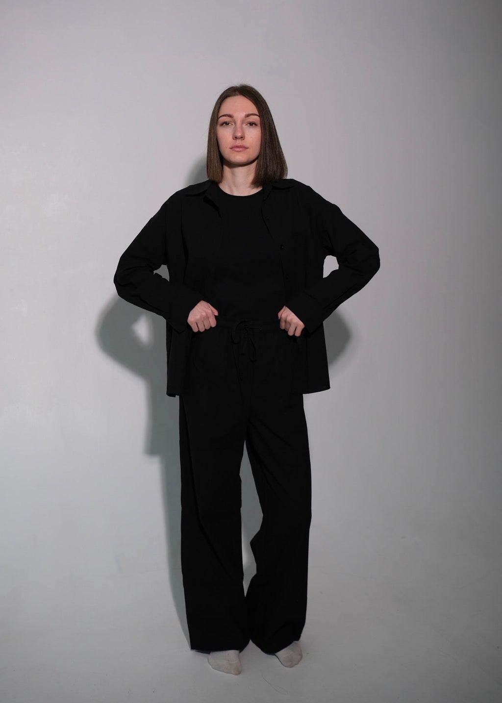 Person wearing a black outfit against a plain background