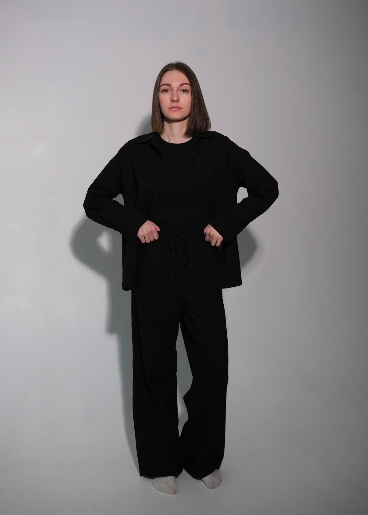 Person wearing a black outfit against a plain background