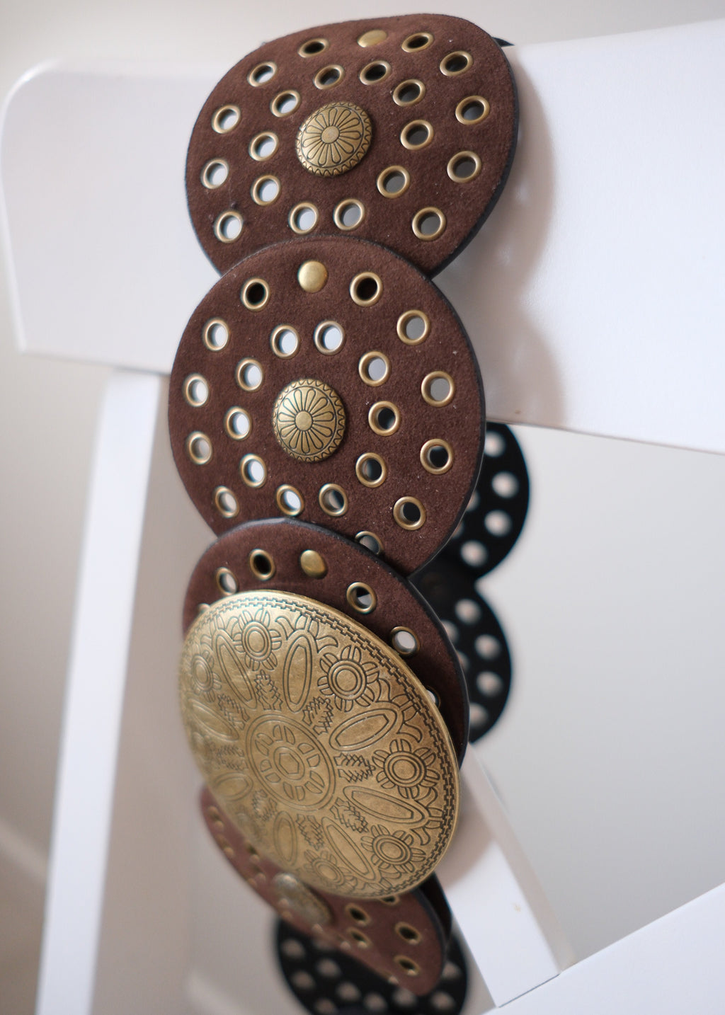 Decorative metal discs with intricate designs on a white background