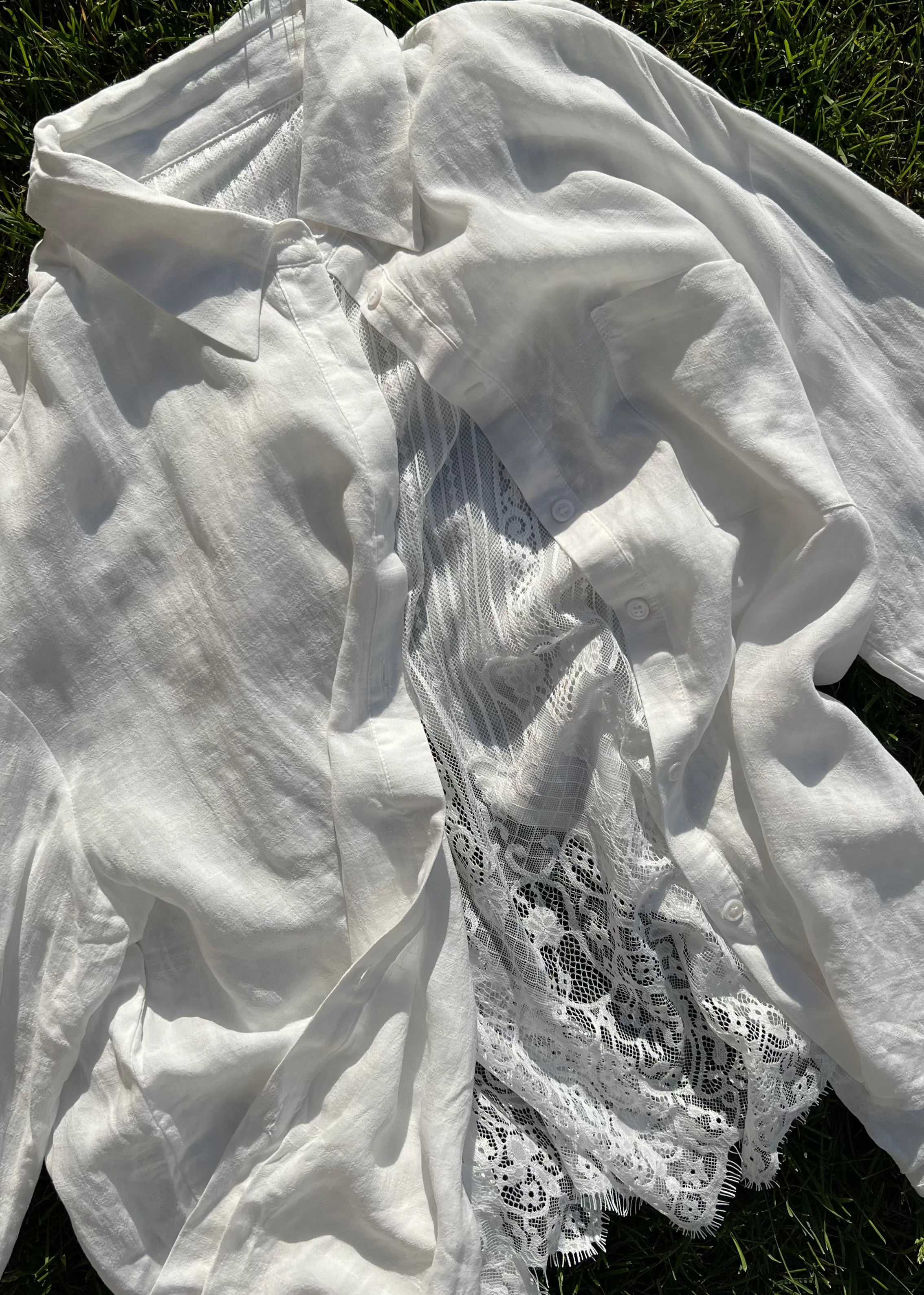 White fabric with lace detailing on a grassy background