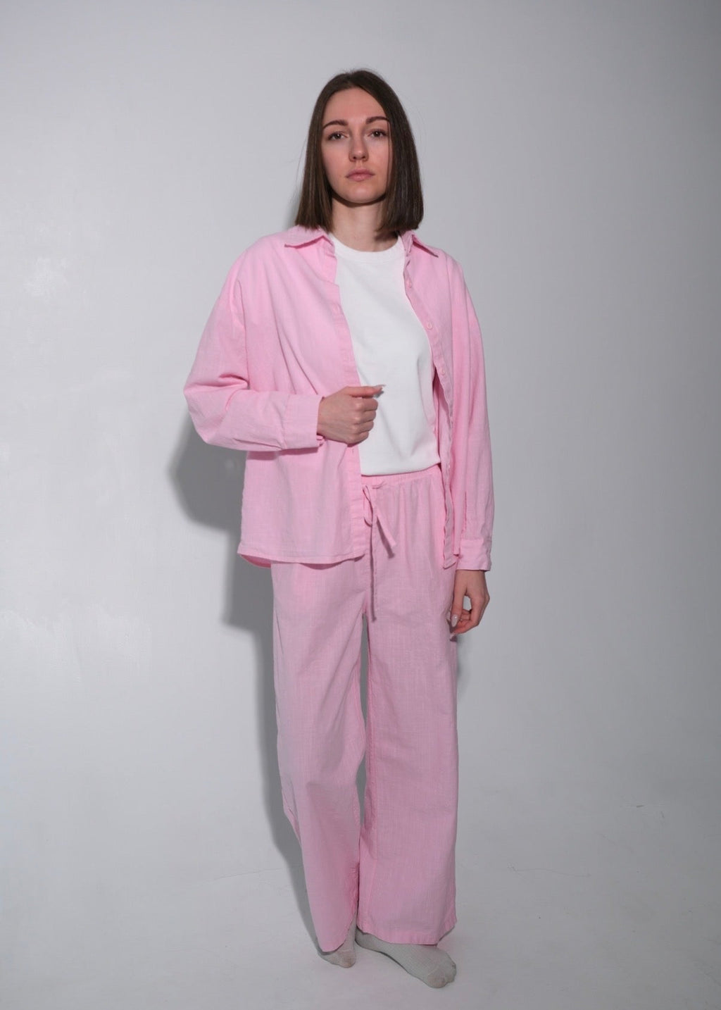Person wearing a pink tracksuit against a plain background