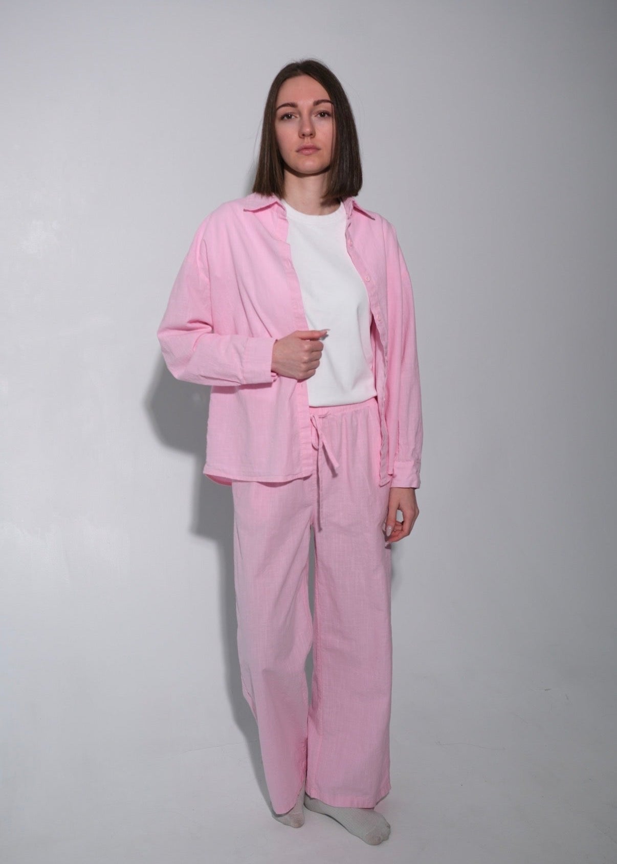 Person wearing a pink tracksuit against a plain background