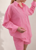 Person wearing a pink pajama set against a plain background