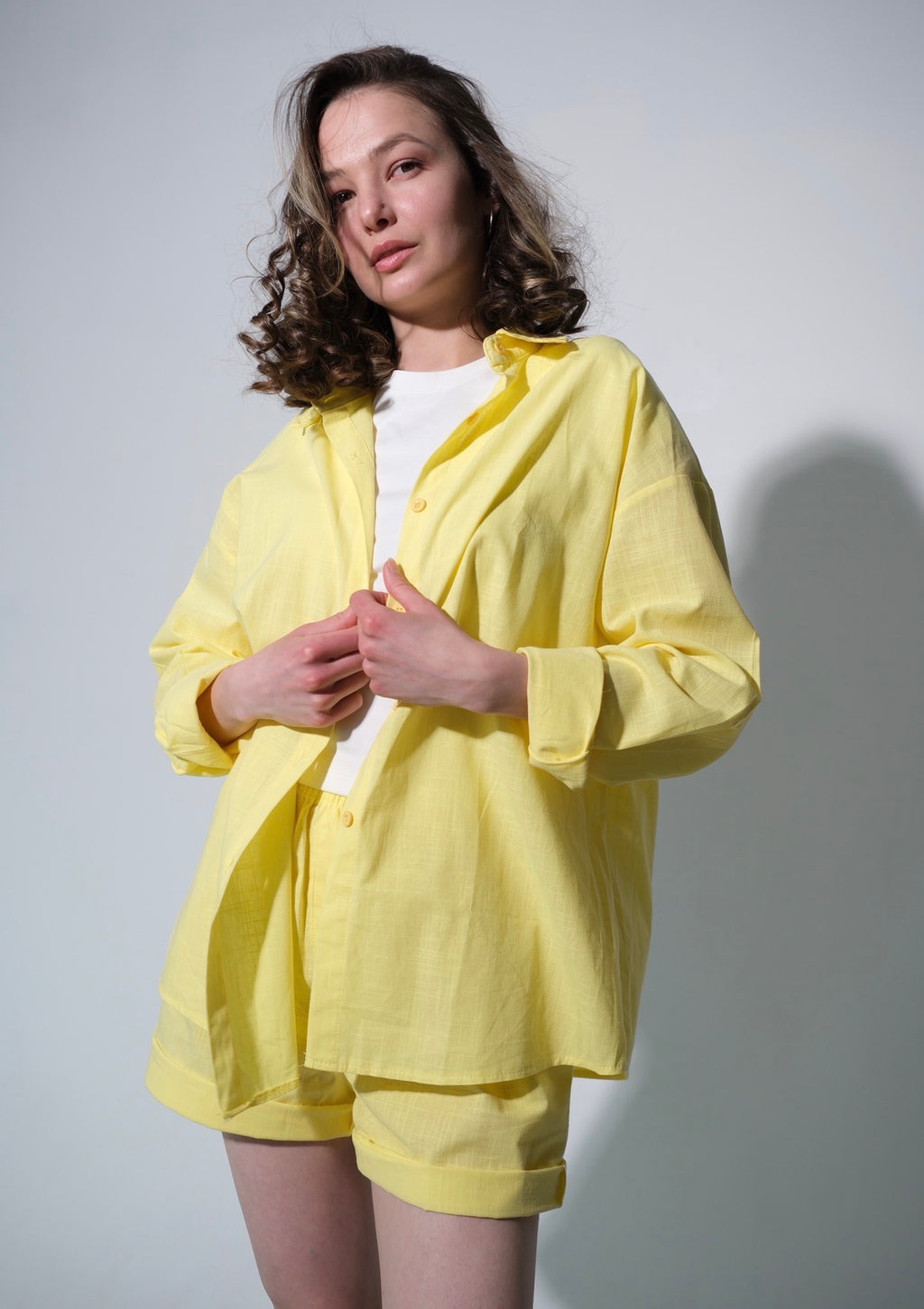 Woman wearing a yellow outfit against a plain background